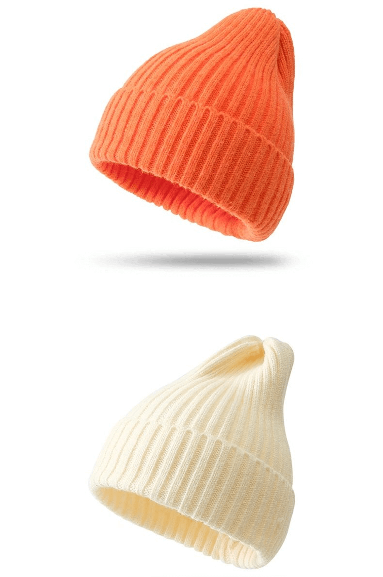 Two stylish knitted women's hats in orange and cream colors, perfect for a cozy and fashionable winter look.