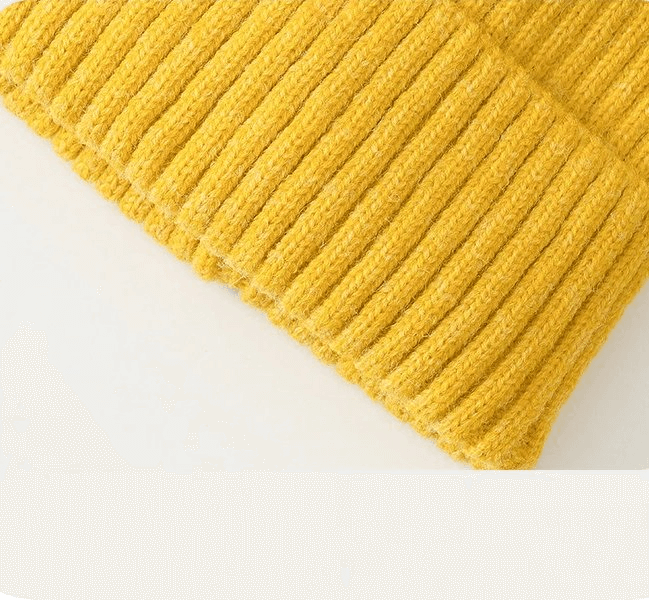Close-up of a stylish knitted yellow plain women's hat made from cozy acrylic and wool blend, perfect for fashion and warmth.