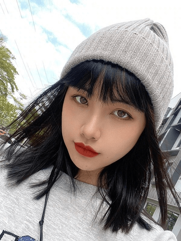 Woman wearing a stylish knitted gray hat, perfect for chic winter fashion.