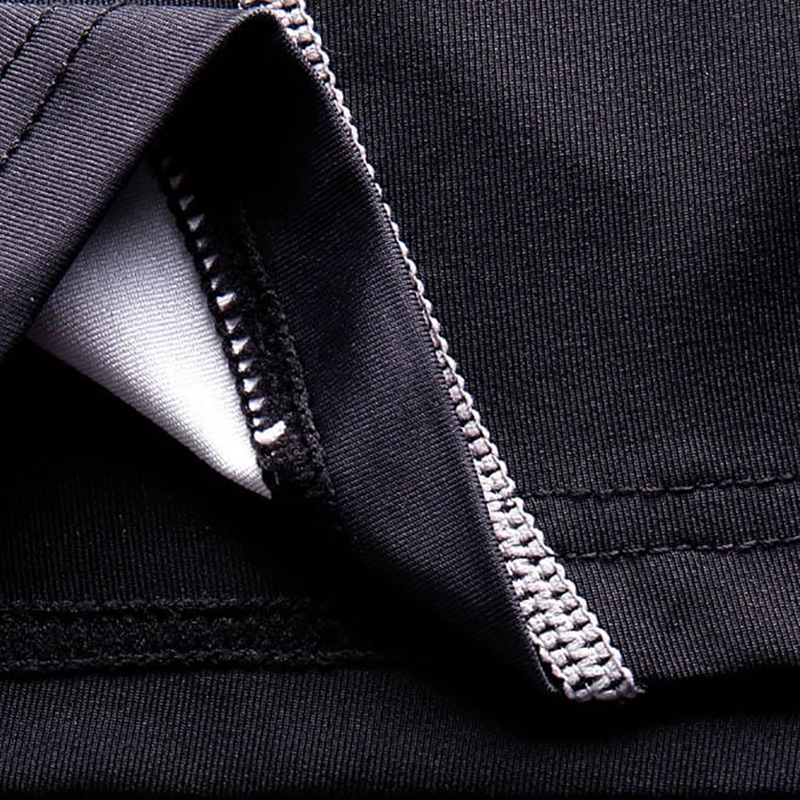 Close-up of stylish black and gray men's compression sports top fabric showing fine stitching details, breathable and stretchy.
