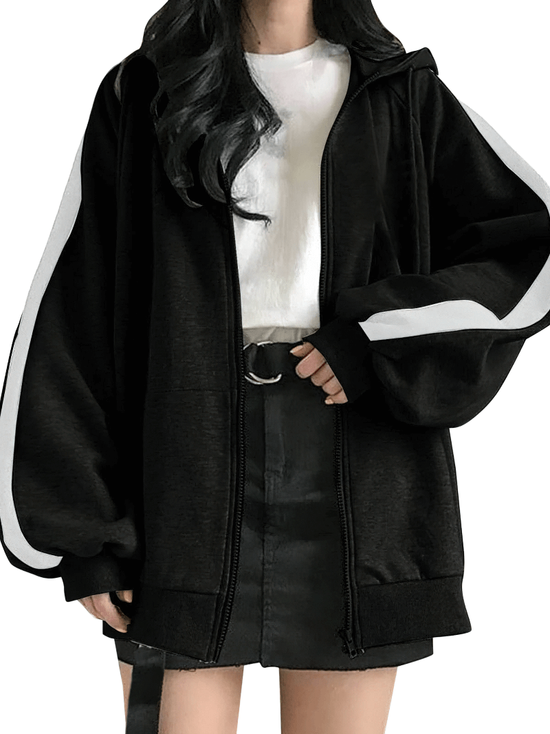 Model wearing stylish loose zipper hoodie for women, oversized fit with hood, black with white stripes, paired with a black skirt.
