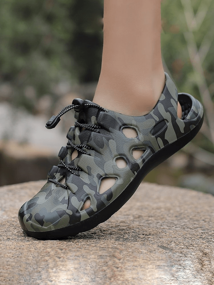 Camouflage men's clogs with quick-dry feature, stylish design, suitable for beach and casual use, displayed outdoors on a rock.