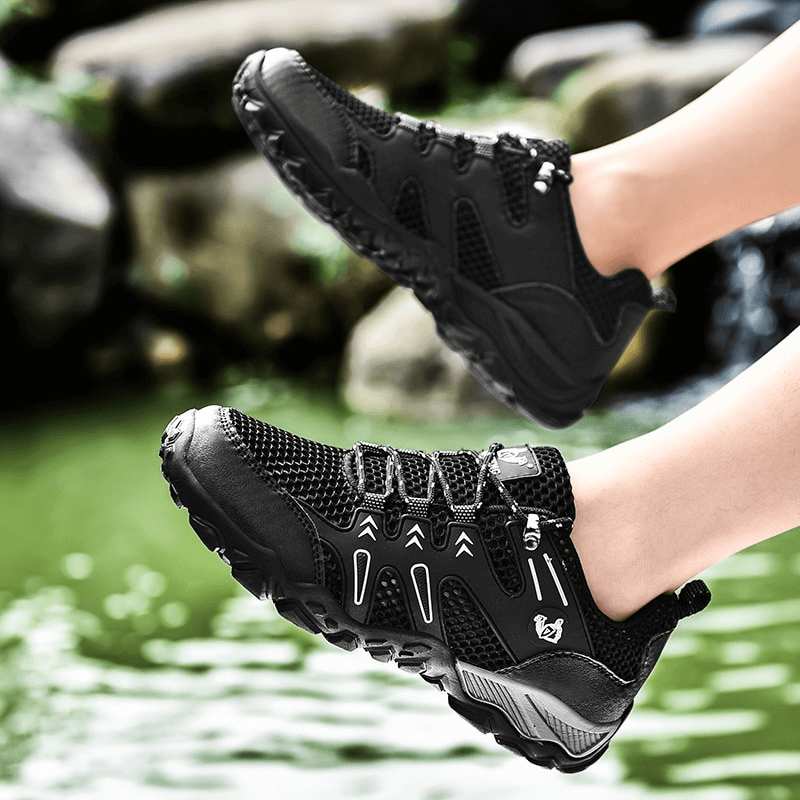 Person wearing stylish mesh breathable sneakers with anti-slip sole near a pond, showcasing lightweight design and comfort.