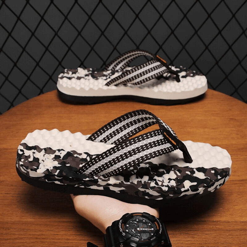 Stylish non-slip massage slippers, men's beach shoes, black and white striped design, displayed on a wooden surface.
