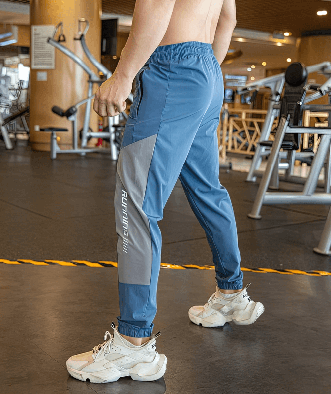 Man wearing stylish quick-drying sporty pants with cuffs in gym, perfect for comfortable running workouts. SF0743.