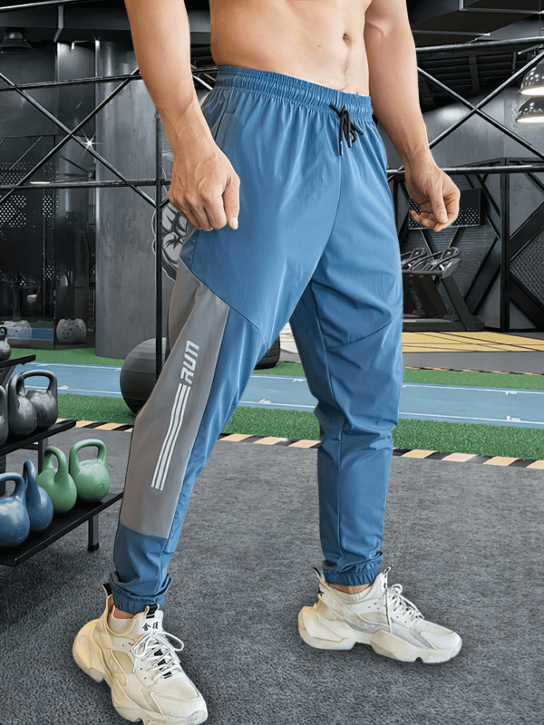 Men's blue sporty quick-drying pants with cuffs, ideal for running and training, featuring a flexible spandex blend and snug fit.
