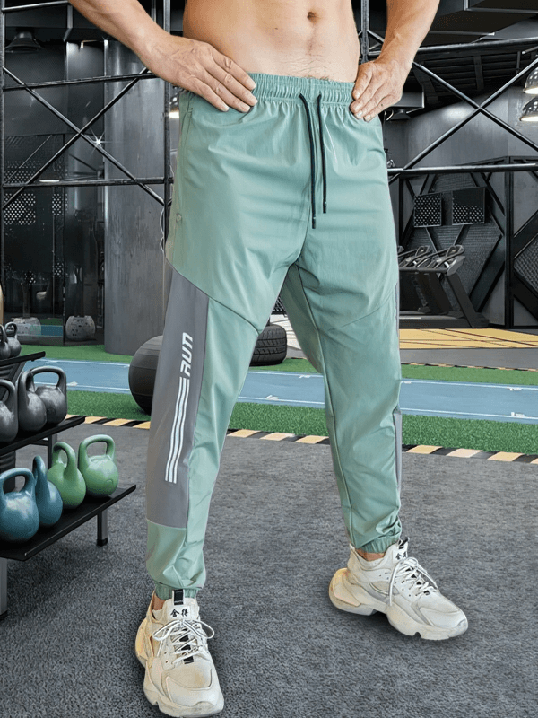 Stylish quick-drying men's pants for training with cuffs and elastic waistband, perfect for running. Model SF0743 in a gym setting.