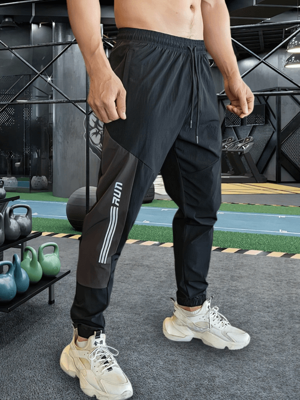 Stylish quick-drying sporty men's pants with cuffs for training, featuring elastic waistband for comfort and flexibility, shown in gym setting.