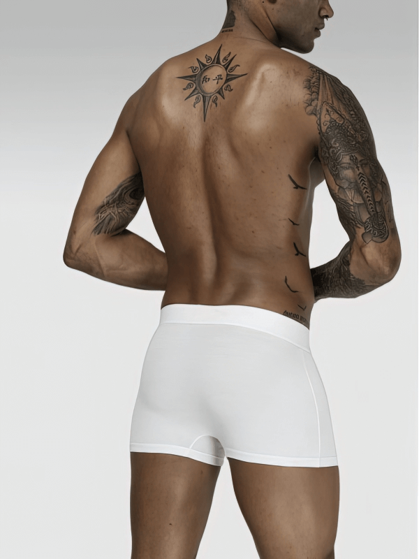 Model wearing stylish soft white sports men's boxers with a tattooed back, showcasing comfort and sleek style.