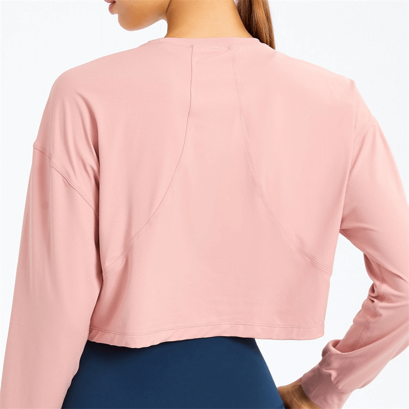 Back view of a pink stylish sport short women's sweatshirt with long sleeves, perfect for yoga. Made with breathable spandex material.