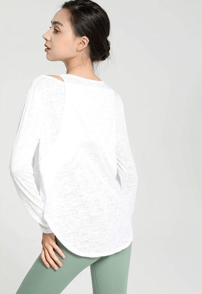 Woman wearing a stylish sporty lightweight top with long sleeves and cutouts, perfect for yoga and active lifestyles.