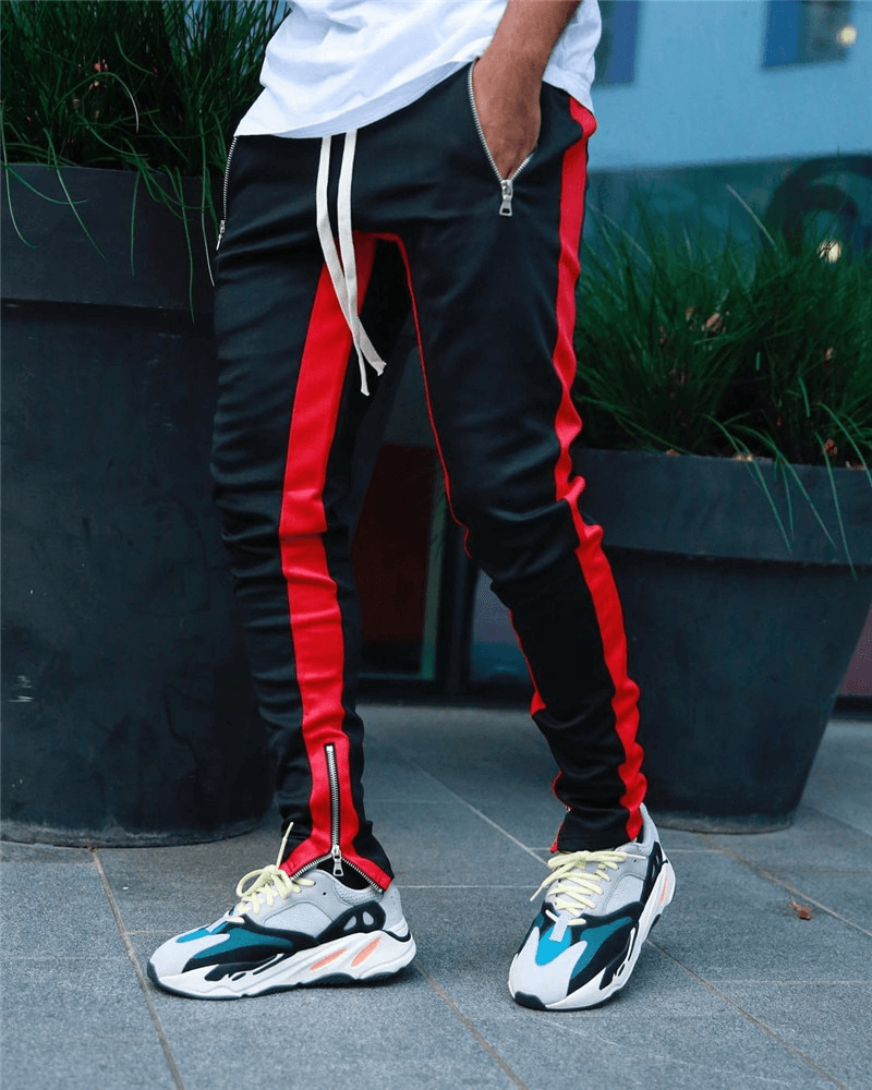 Men's stylish two-tone jogging pants with zipper pockets, shown in red and black, perfect for sports and running comfort.