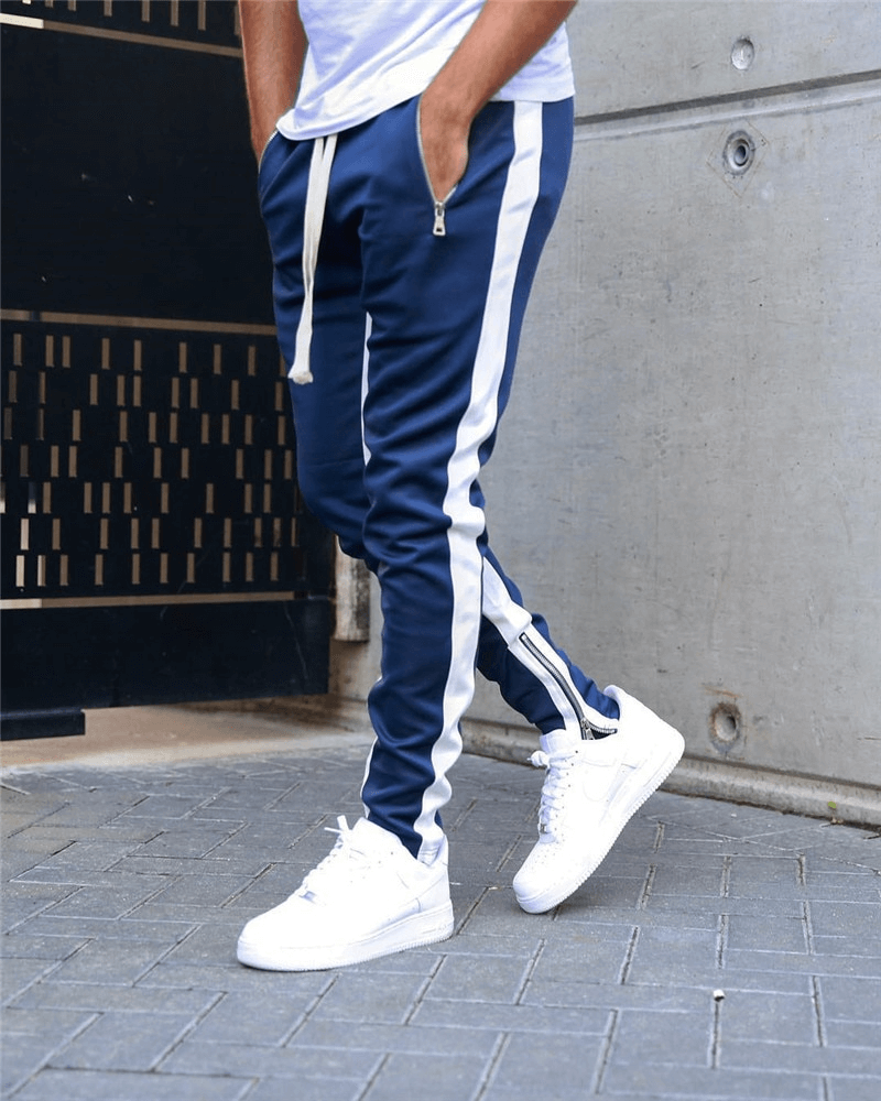Man wearing stylish two-tone jogging pants with zipper pockets, perfect for running, showcasing comfortable fit and sporty design.