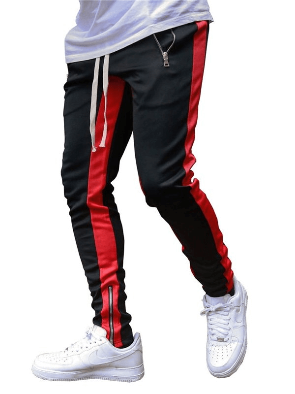 Stylish two-tone sports jogging pants for men with zipper pockets in black and red, featuring a drawstring closure and white sneakers