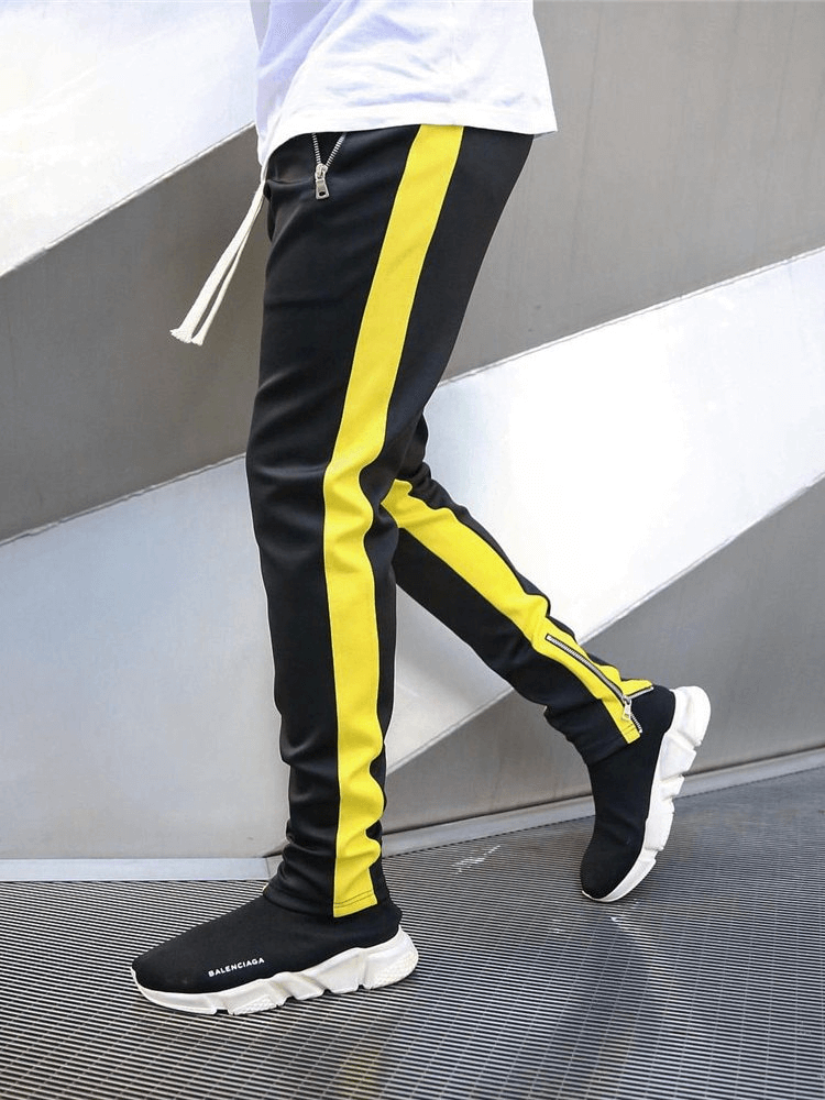Stylish two-tone sports jogging pants for men with yellow stripe and zipper pockets, ideal for running, shown in side view.