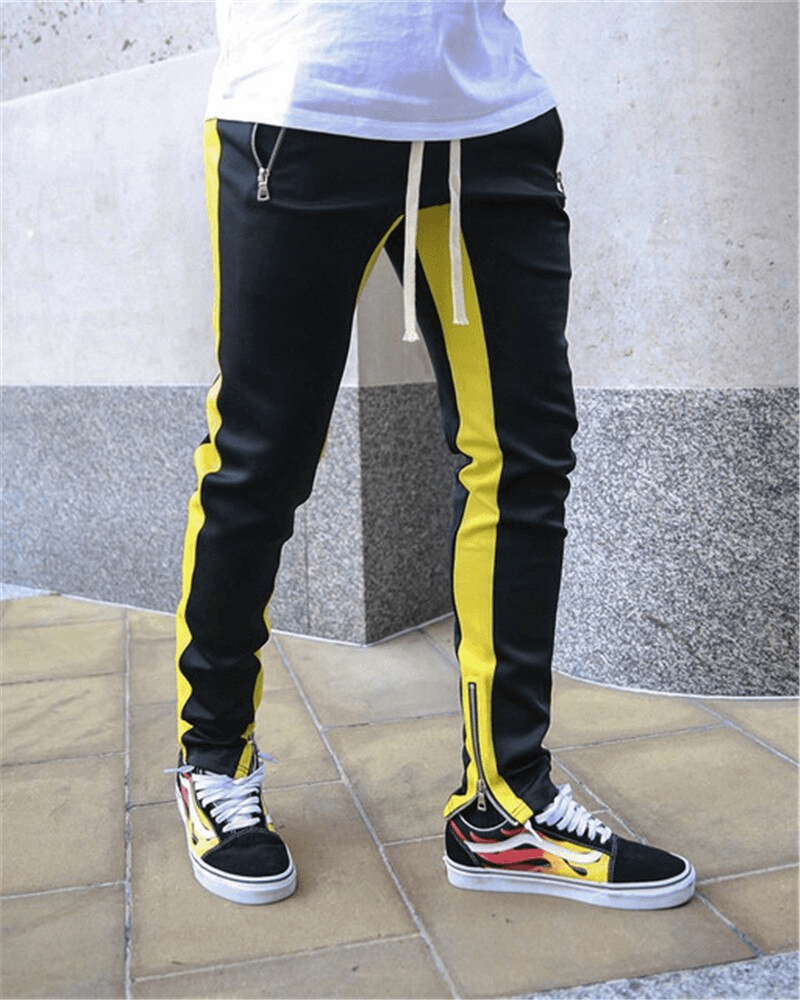 Two-tone sports jogging pants for men with zipper pockets and drawstring, shown in black and yellow, perfect for running.