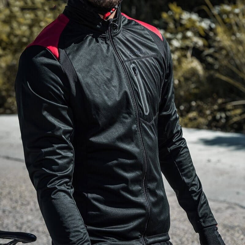 Man wearing stylish warm bike jacket with high slit pockets, black polyester, windproof and breathable for cycling.