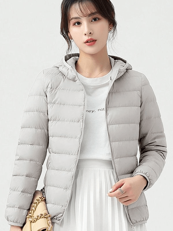 Woman wearing a stylish lightweight down jacket with hood, showcasing windproof, waterproof features ideal for outdoor activities.
