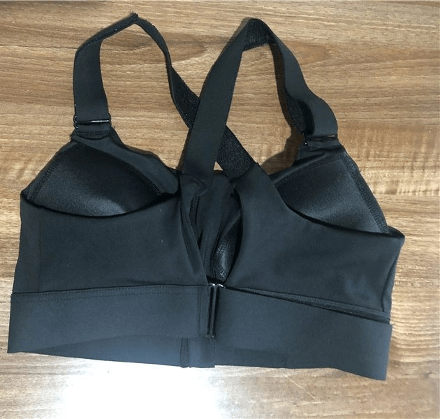 Black Stylish Women's Shockproof Sports Bra with Adjustable Fastening on Wooden Surface