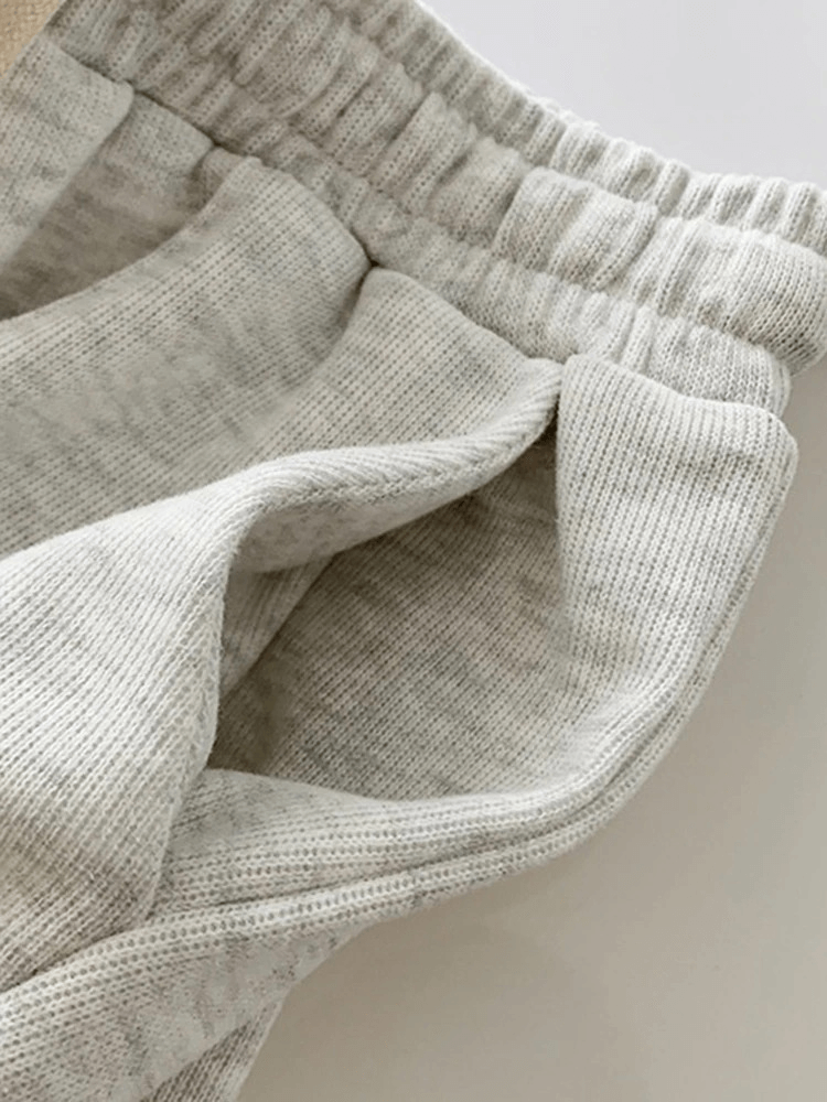 Close-up of stylish women's high-waist shorts with elastic band and side pocket in grey premium cotton. Perfect casual style.