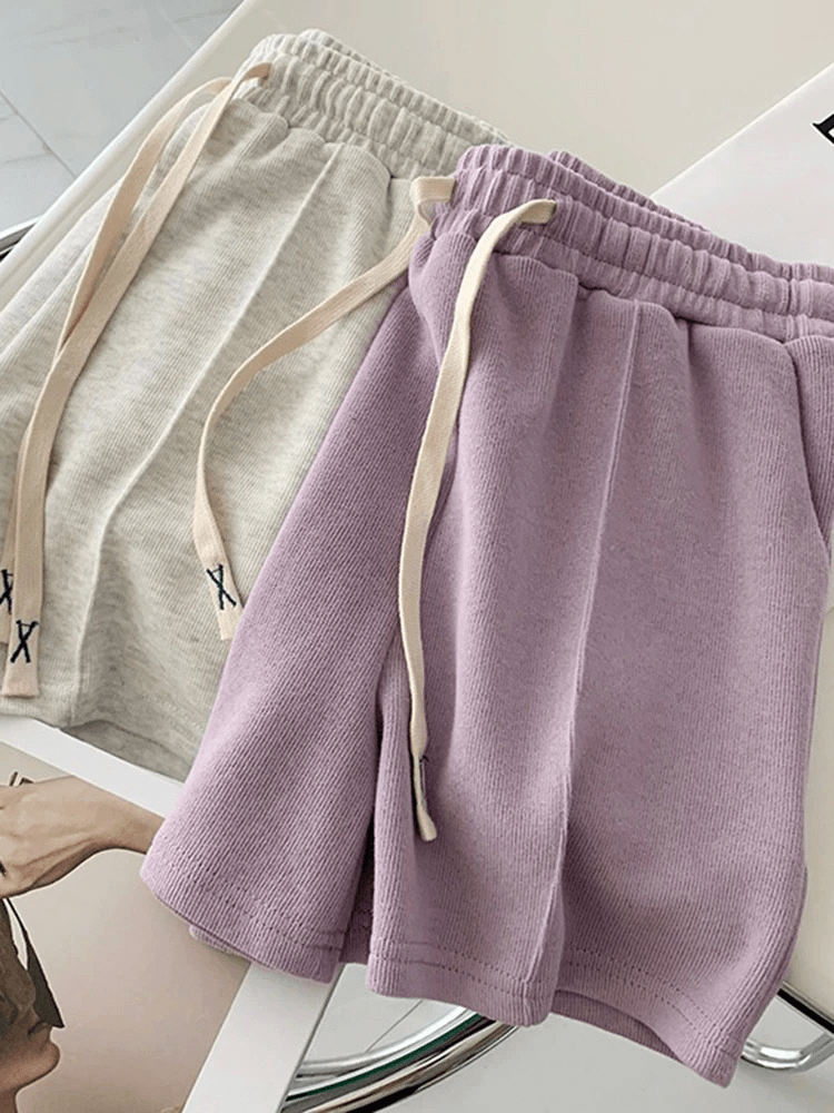 Stylish women's high-waist shorts in pastel colors with elastic waist and side pockets, perfect for casual wear.