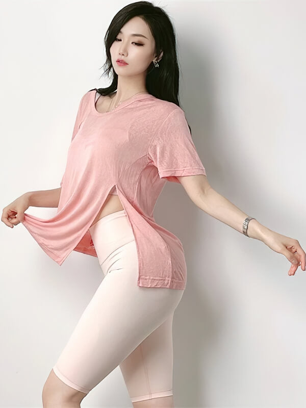 Woman wearing a stylish cropped sports top with side cut, ideal for yoga, made of breathable nylon and spandex for comfort.