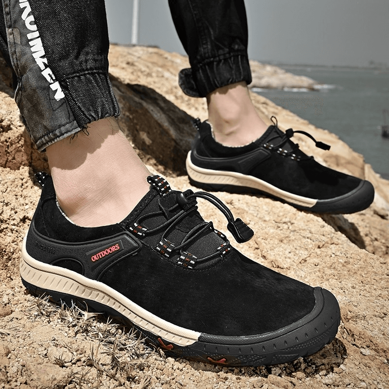 Men's suede leather non-slip hiking shoes with elastic band, SF0719, on rocky terrain.