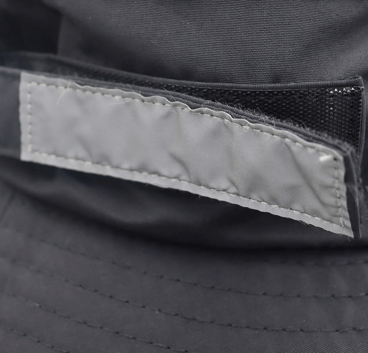 Close-up of the closure on a breathable waterproof wide brim hat, showcasing durable stitching and lightweight design.