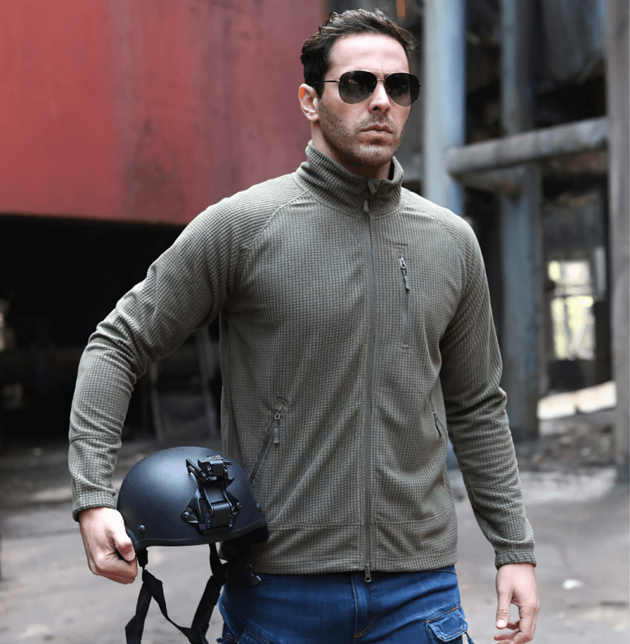 Man in Tactical Lightweight Fleece Jacket SF0350, holding a helmet in an urban setting.