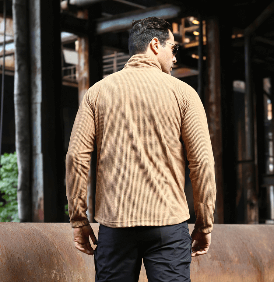 Man wearing a khaki tactical lightweight fleece jacket standing outdoors, illustrating the warm and stylish design.