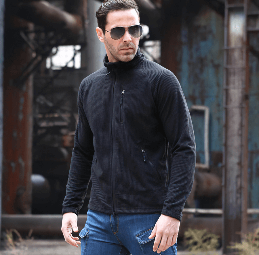 Man wearing black lightweight tactical fleece jacket, stylish warm army clothing for men, perfect for outdoor adventures.