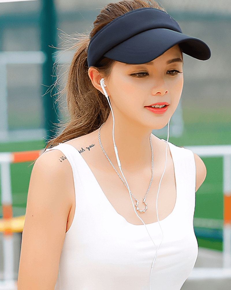 Woman wearing black UV protection tennis golf visor cap outdoors.