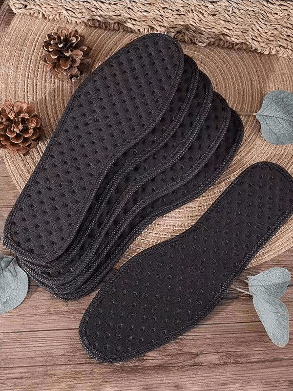 Stack of black antibacterial shock-absorbing insoles for sports shoes, featuring textured design, on a rustic surface.