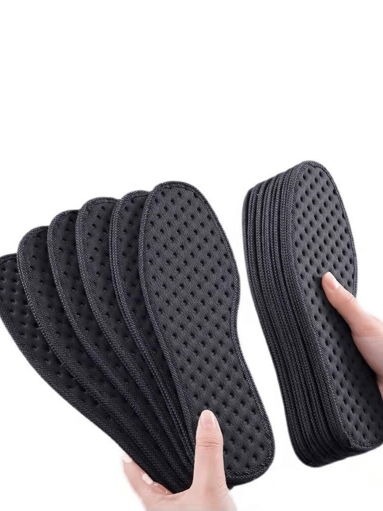 Stack of black thickened shock absorbing antibacterial insoles for sports shoes, held in hands, showcasing light weight and durability.