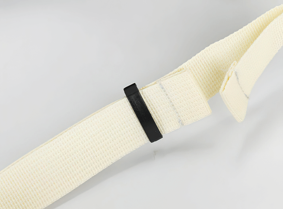 Close-up of a beige woven strap with black plastic buckle for travel backpack adjustment.