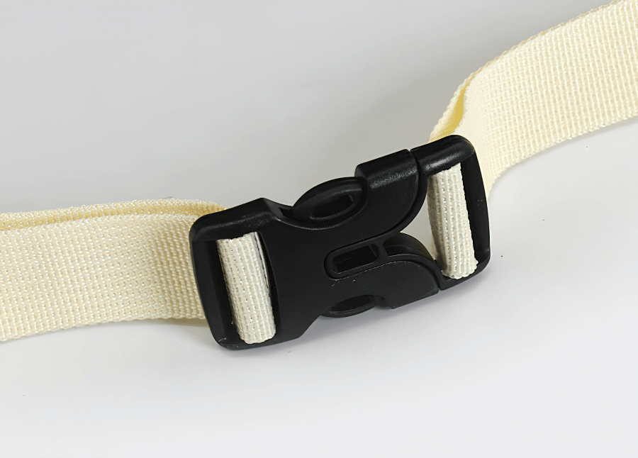 Close-up of a durable black plastic buckle on a beige nylon strap, ideal for securing travel backpacks or outdoor sports bags.