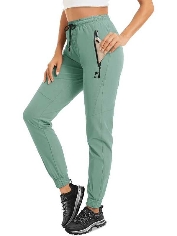 Travel Women's Quick-Drying Pants with Zippered Pockets in green, featuring durable fabric and drawstring closure.