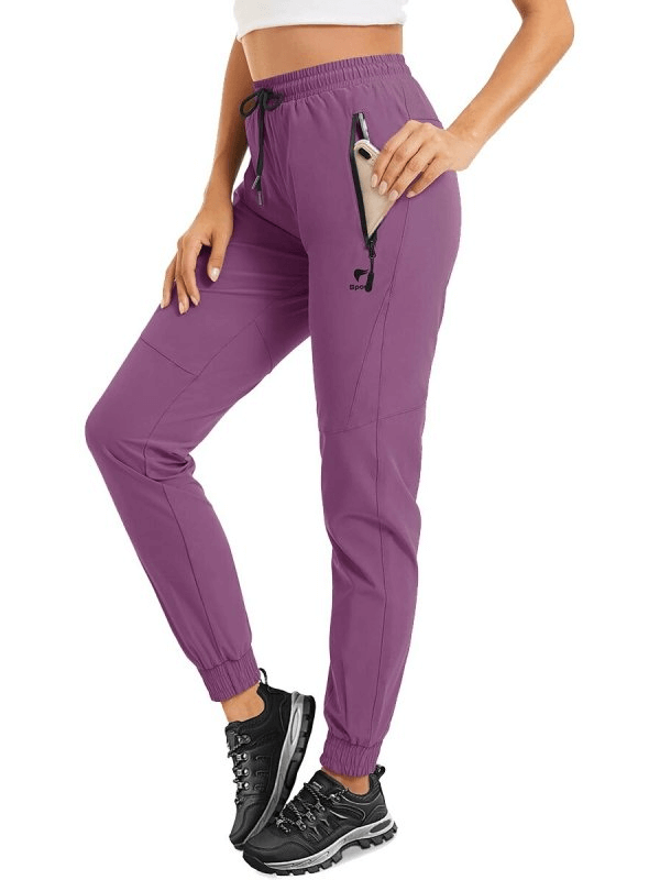 Purple women's quick-drying pants with zippered pockets and drawstring, perfect for travel and active wear.