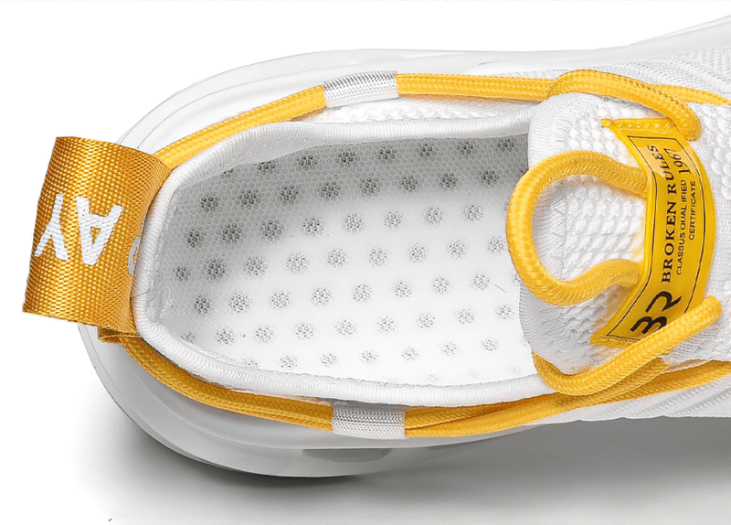 Close-up of yellow and white unisex mesh breathable running shoe with lace-up design, showcasing the detailed insole and quality finish.