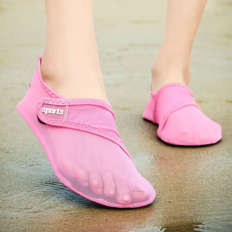 Pink unisex mesh water shoes with breathable design on sandy beach, perfect for summer activities.
