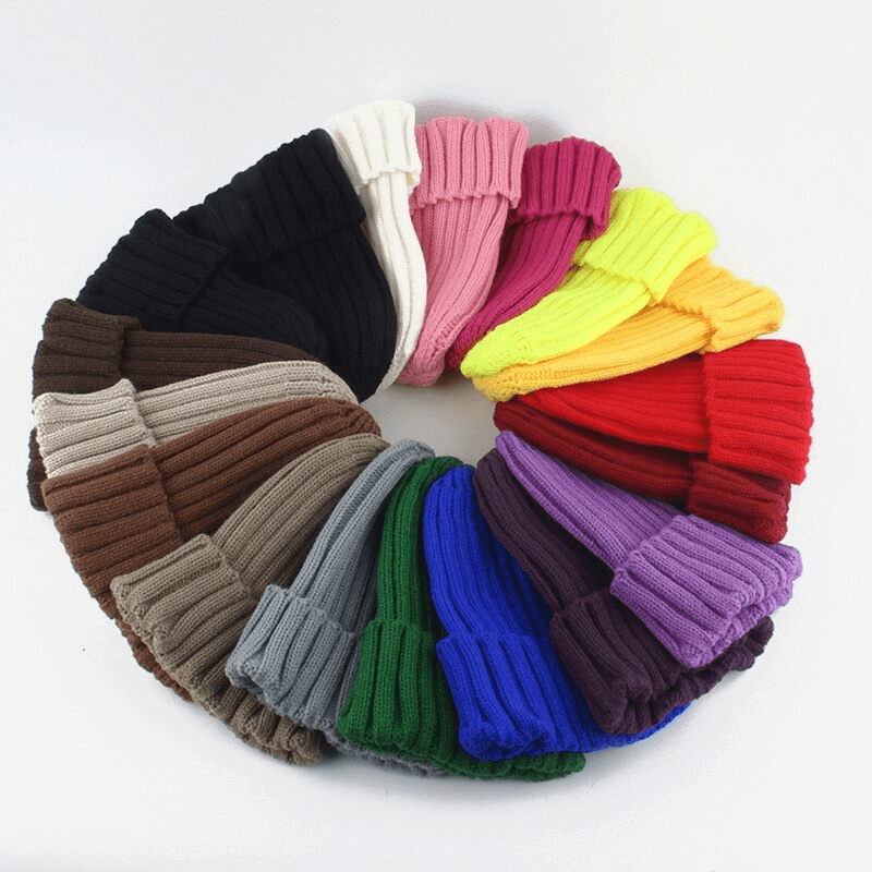 Colorful array of unisex knitted hats in solid colors, perfect for staying warm and stylish. Made with cotton and acrylic for comfort.