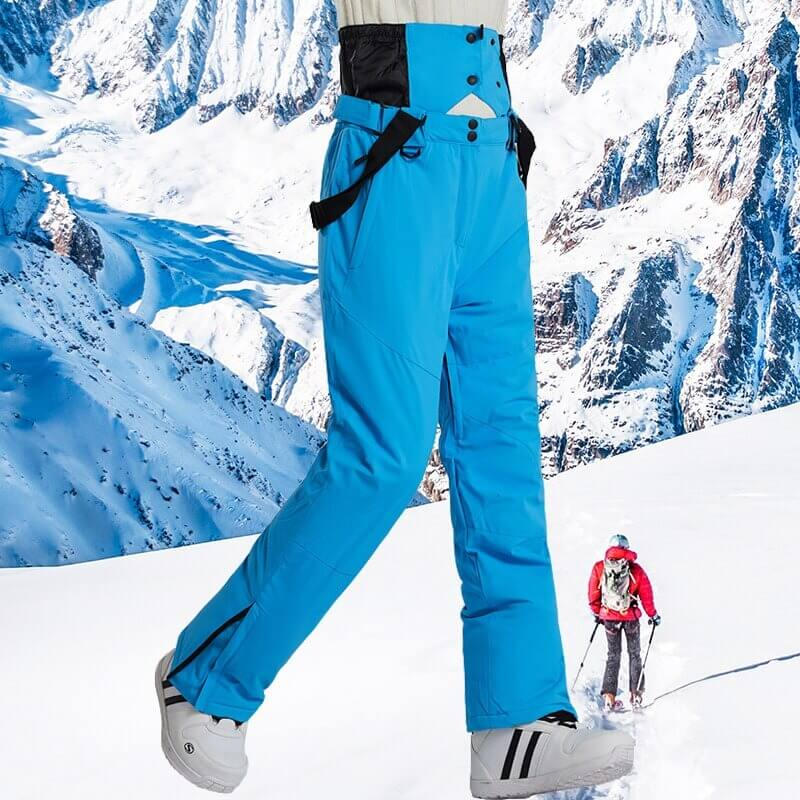 Blue warm ski trousers with suspenders on snowy mountain, unisex design for men and women. SF0597 skiing gear for warmth and comfort.