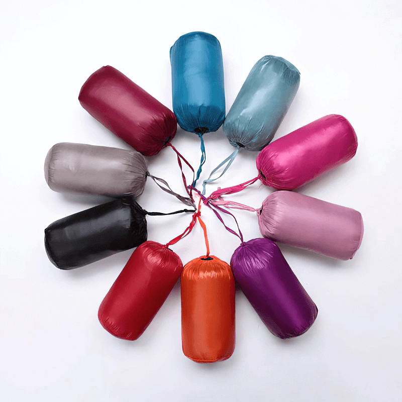 Colorful assortment of packable warm women's vests in travel pouches, showcasing vibrant options for ultra-light outwear, SF0090 model.