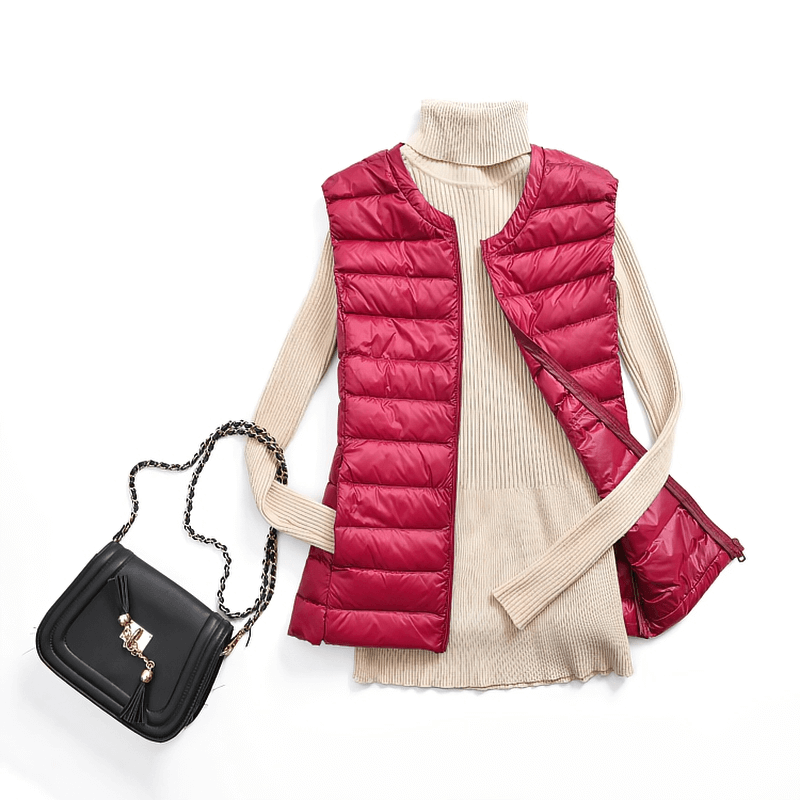 Red women's vest with pockets over beige sweater and black handbag, perfect for stylish warmth.
