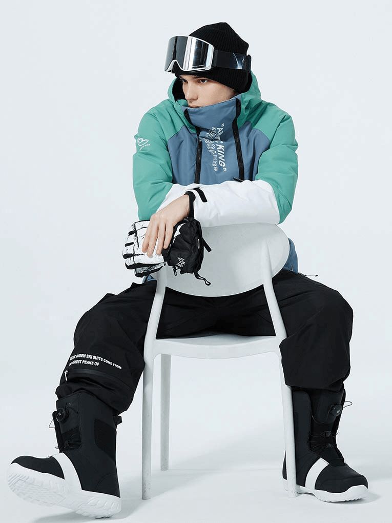 Unisex wearing warm waterproof snowboarding jacket with double zipper, hooded collar, sitting on chair ready for skiing adventure.
