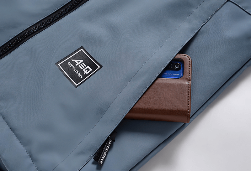 Close-up of a Warm Waterproof Snowboarding Jacket SF0943 with double zipper pocket holding a smartphone.