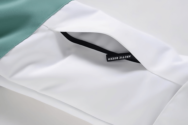 Close-up of waterproof snowboarding jacket pocket featuring a stylish black zipper.