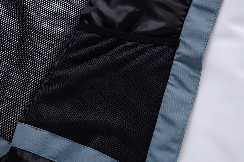 Close-up of the inner lining of a warm waterproof snowboarding jacket featuring durable stitching and breathable fabric.
