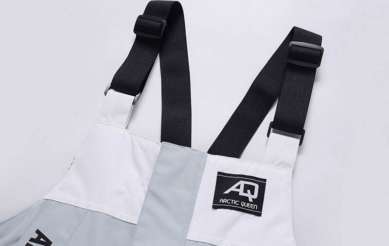 Close-up of warm waterproof snowboarding jumpsuit with black zipper straps, ideal for skiing. Unisex polyester blend, breathable and lightweight.