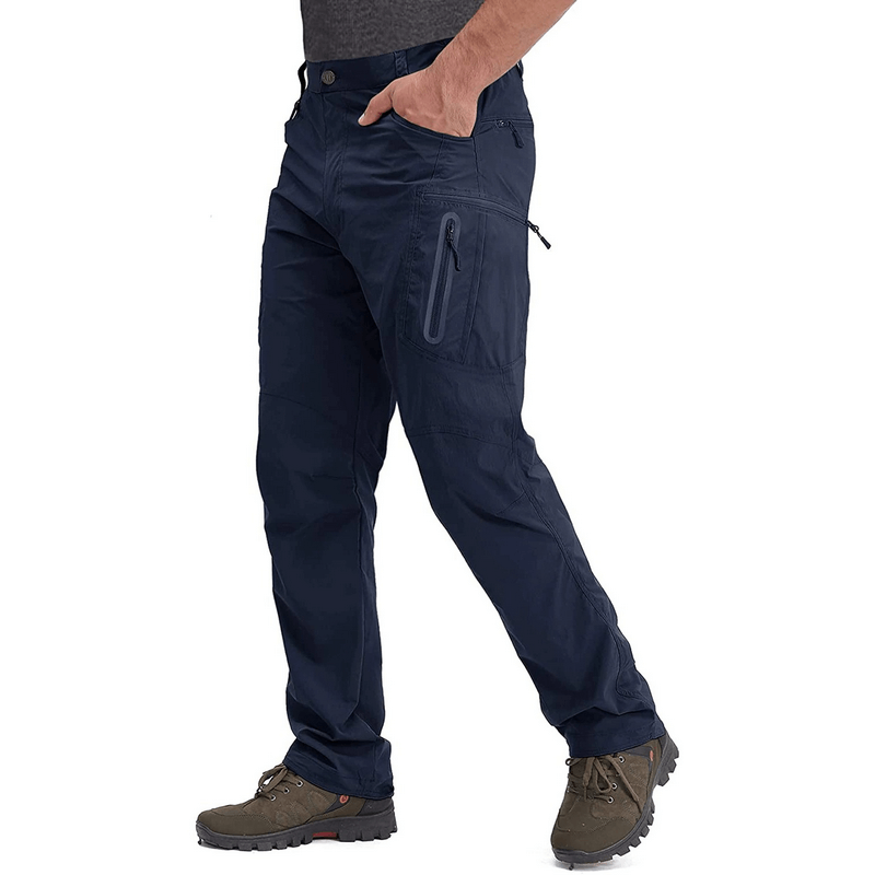 Man wearing navy water resistant lightweight fishing pants with zipper pockets, ideal for outdoor activities and adventures.